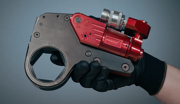 A gloved hand holds the HYTORC XLCT limited clearance hydraulic torque wrench